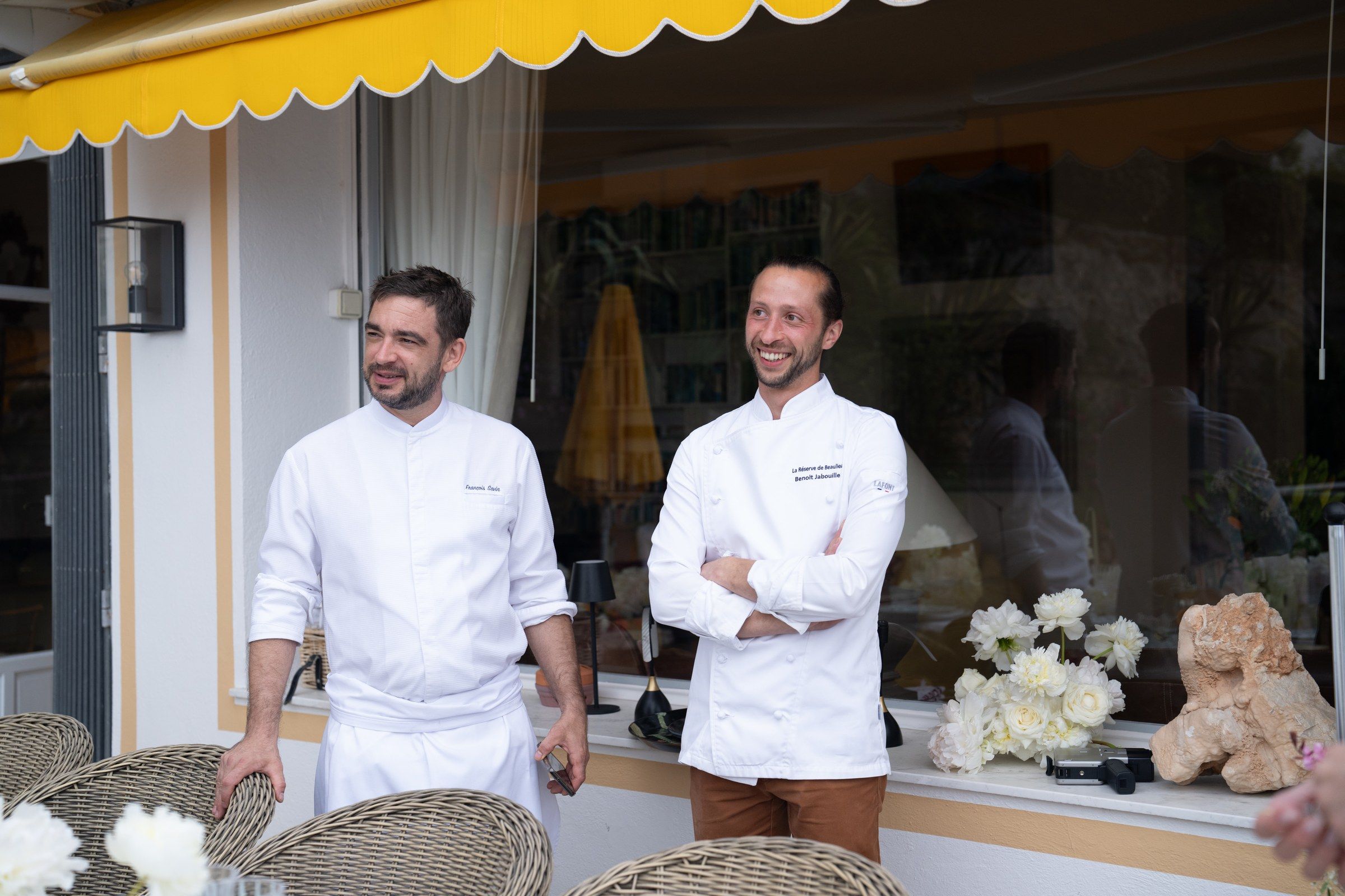Riviera villa terrace set for a private dinner, sea view in the distance.