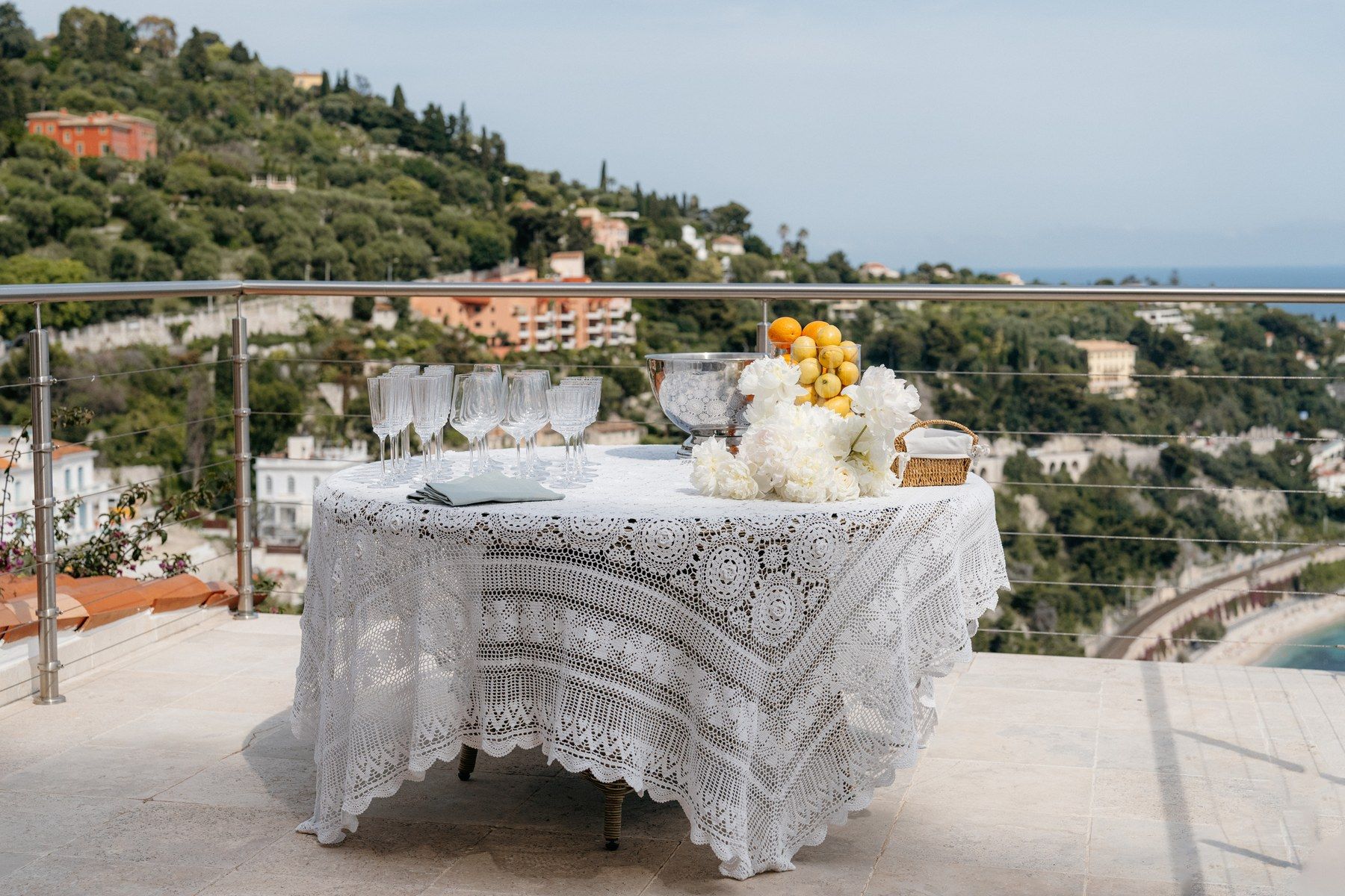 Long event table dressed with white florals on a Riviera terrace.